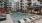 a pool in a courtyard with chairs and cabanas